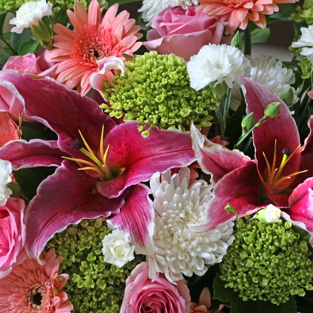 An elegant white sympathy bouquet in a low ceramic vase